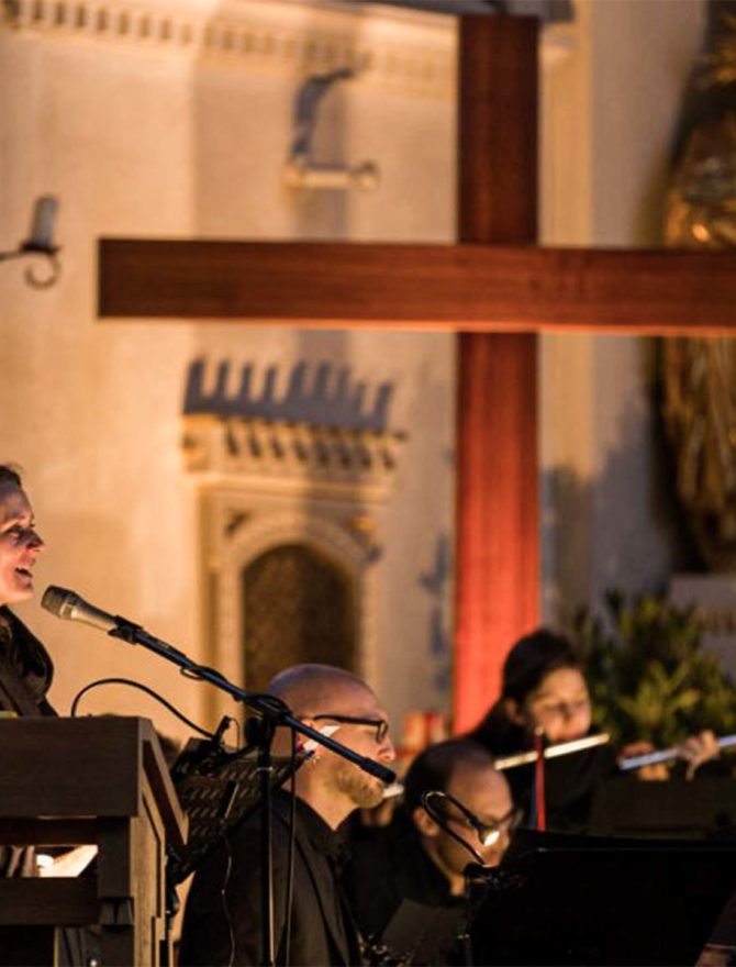 Adonai-Kreuzweg: Musiker spielen in einer Kirche unter dem Kreuz