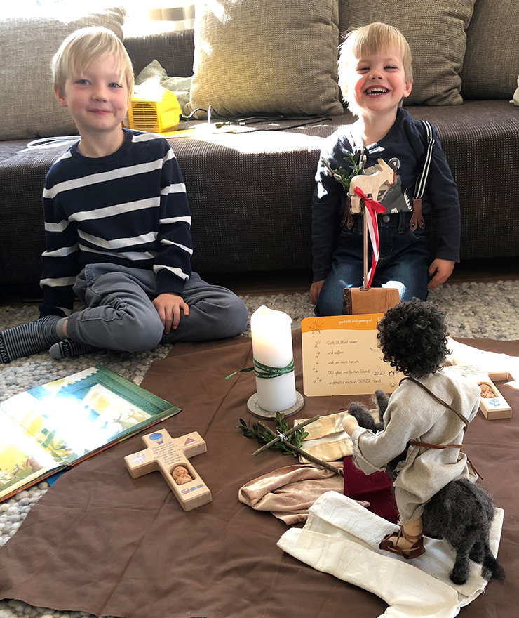 Zwei blonde Jungen feiern Gottesdienst im Wohnzimmer