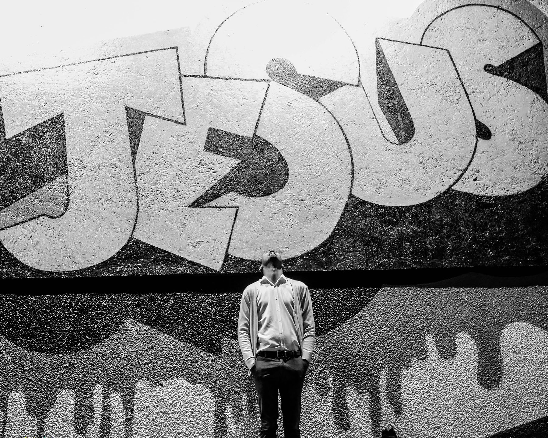 Junger Mann vor Graffiti mit Jesus