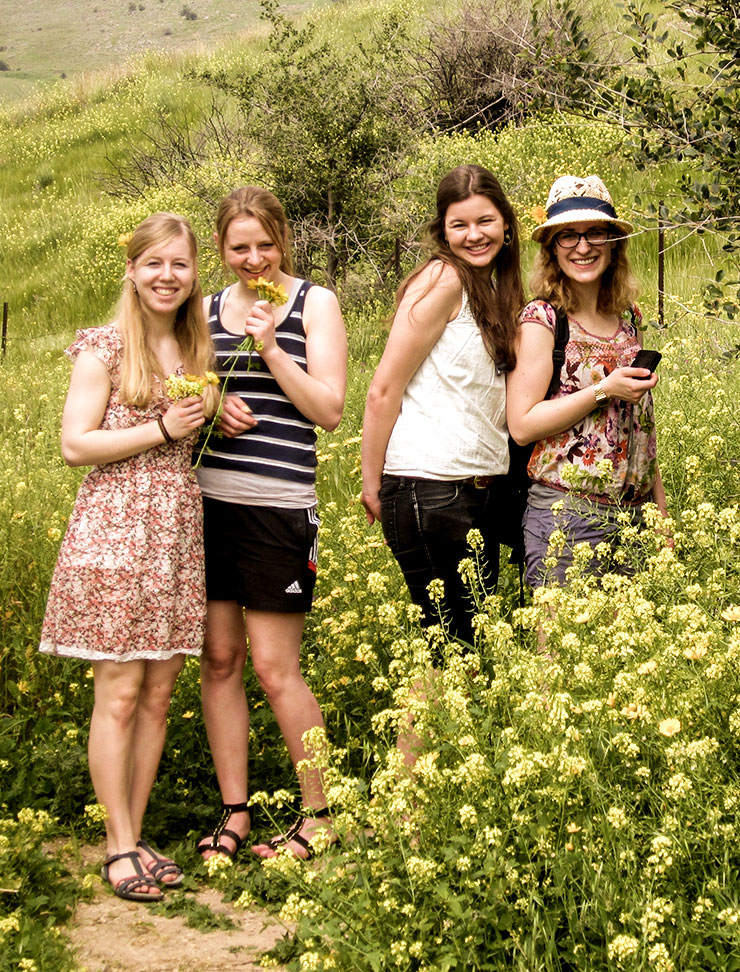 Vier junge Frauen in einem Blumenfeld
