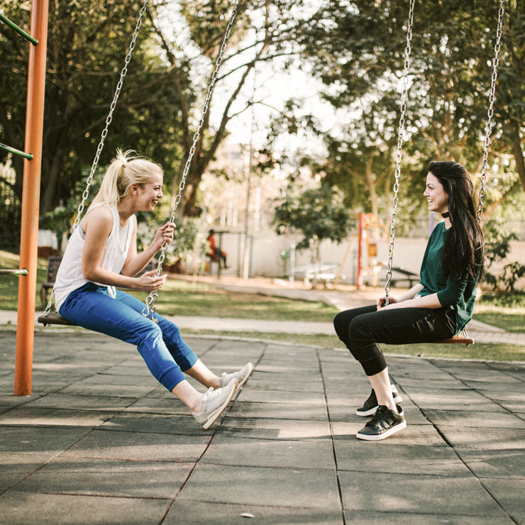 Zwei Freundinnen unterhalten sich auf einem Spielplatz