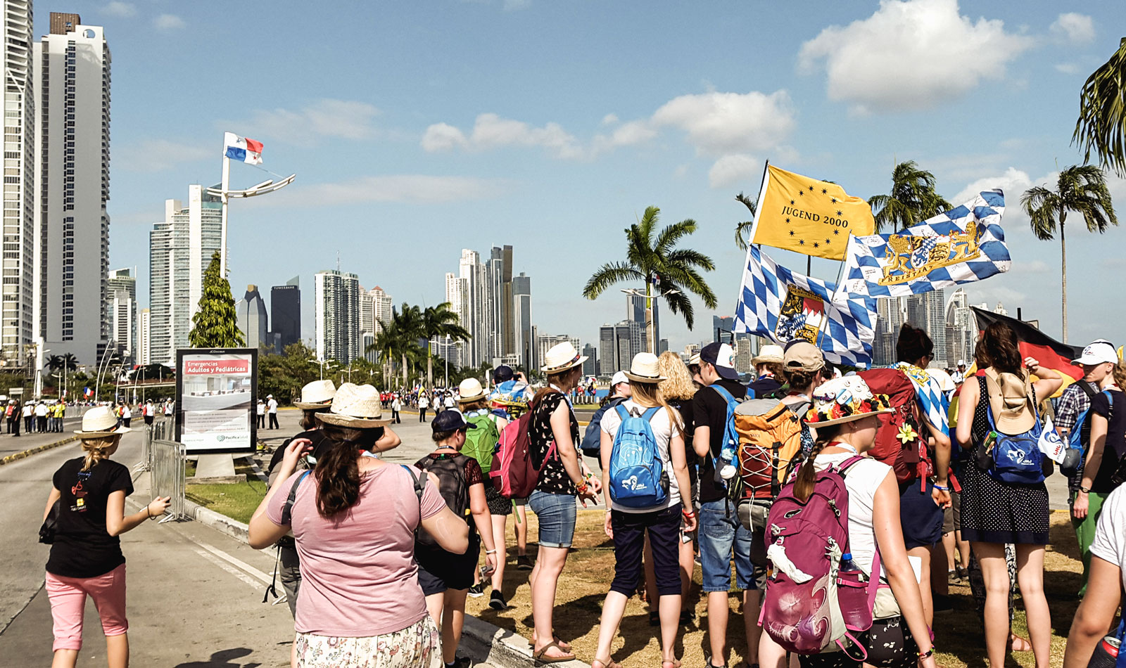 Eine Gruppe junger Menschen mit Bayern-Fahnen vor der Skyline von Panama City