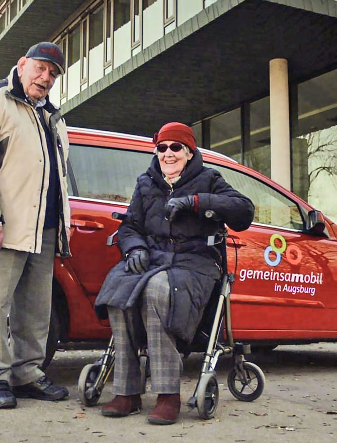 Zwei Senioren vor einem roten Carsharing-Auto