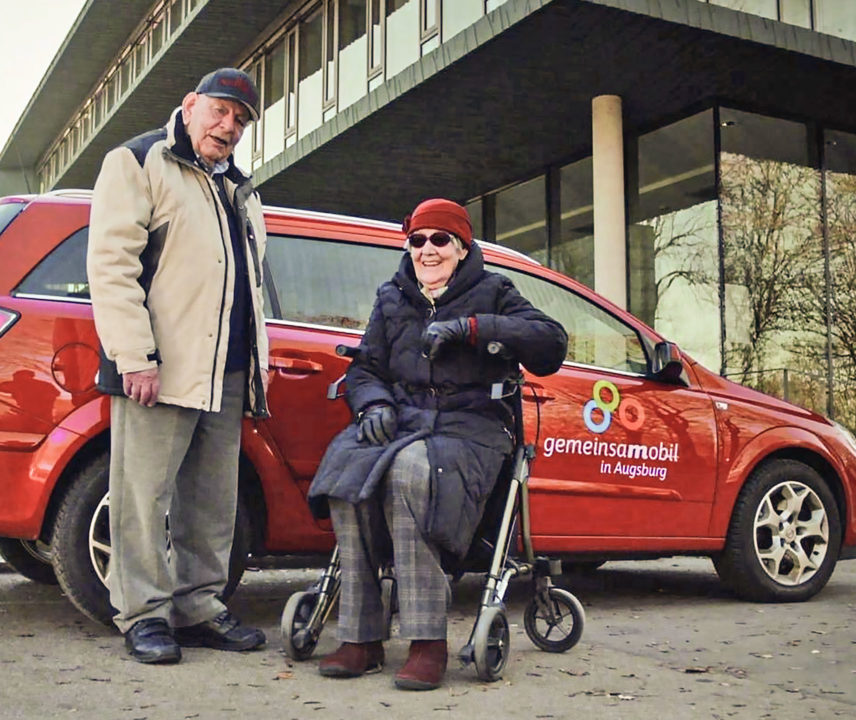 Zwei Senioren vor einem roten Carsharing-Auto