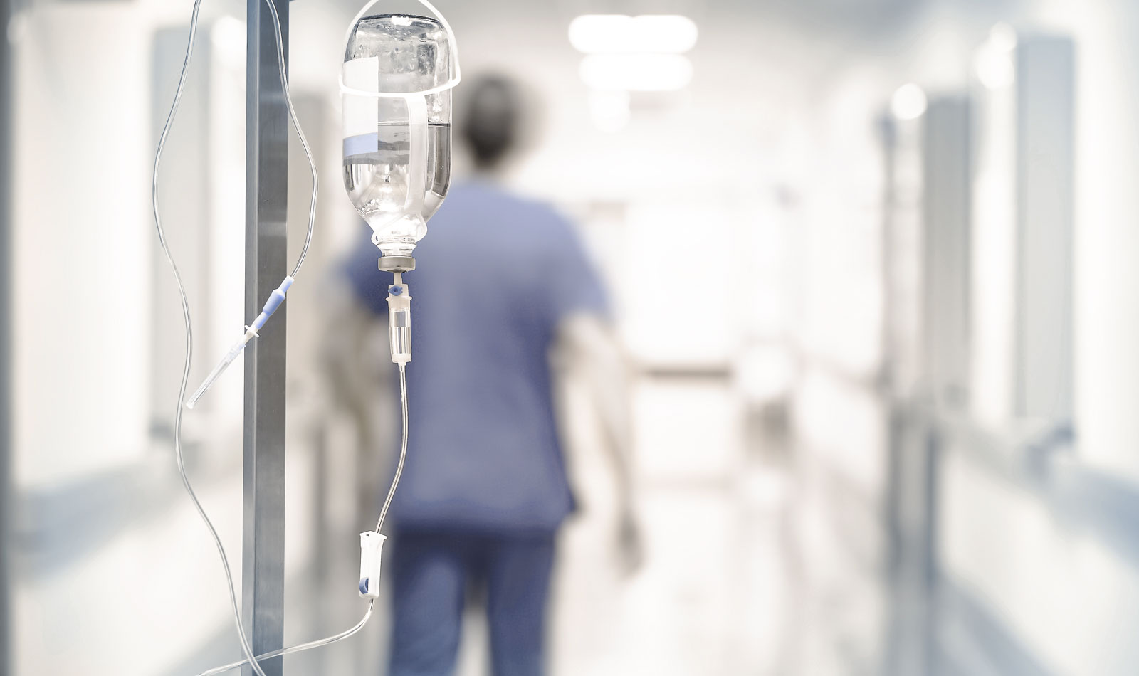 Krankenhausgang mit Infusionsflasche im Vordergrund