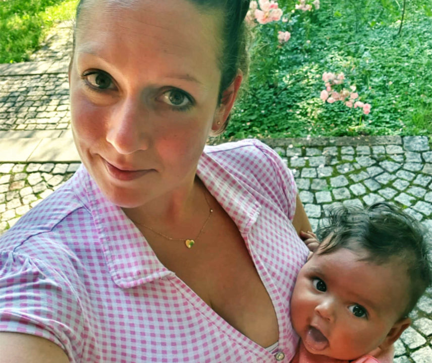 Junge Frau in Trachtbluse mit Baby im Arm