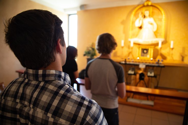 Junge erwachsene Christen beten das Allerheiligste an.