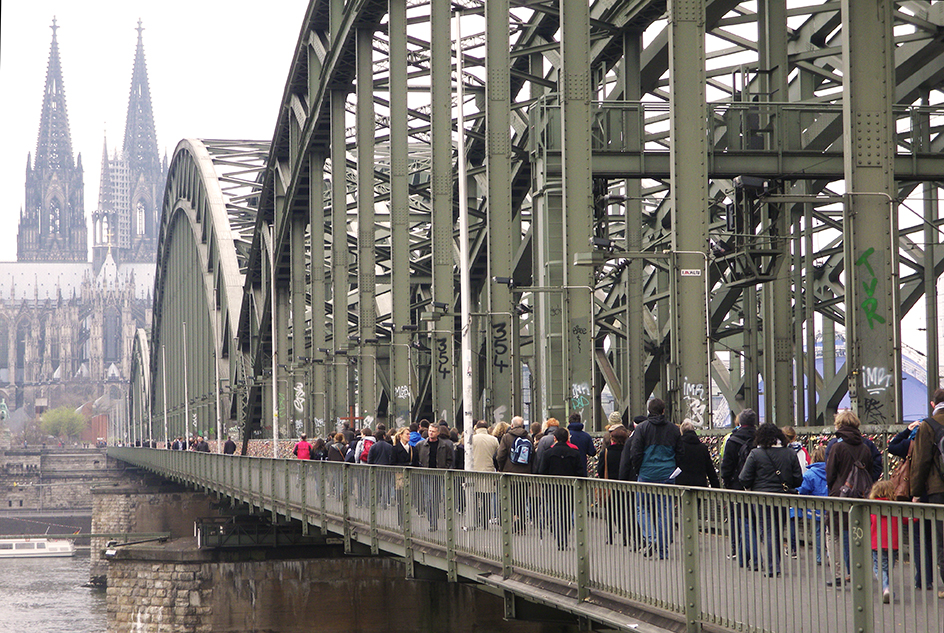 Pilger in Köln auf der Rheinbrücke mit Dom im Hintergrund