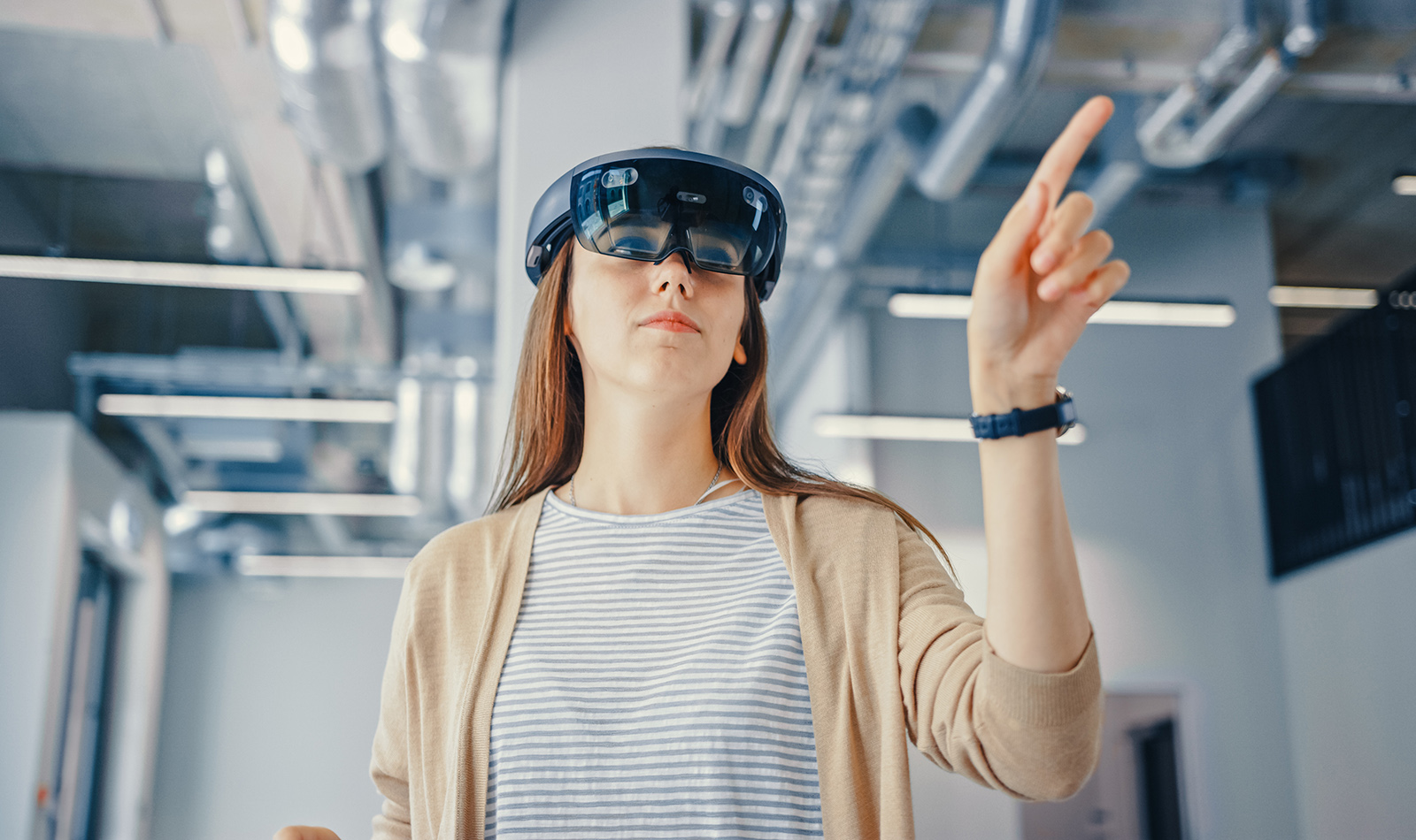 Junge Frau mi langen roten Haaren mit Augemented Reality Brille im Büro