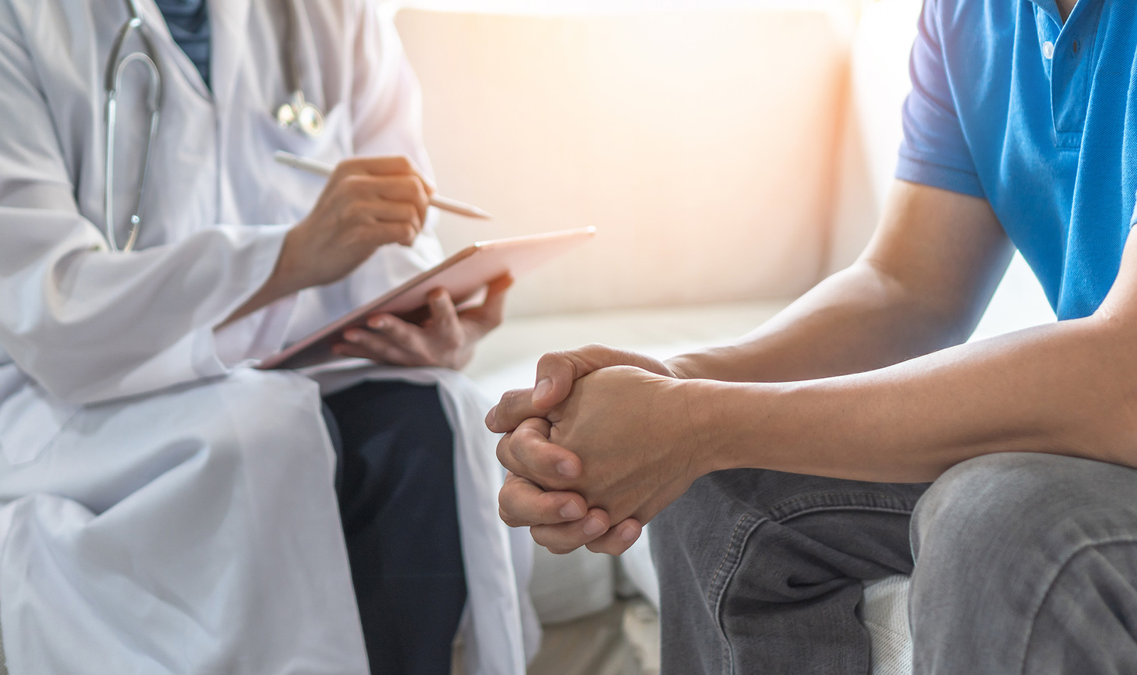 Arzt stellt jungem Menschen eine Diagnose.