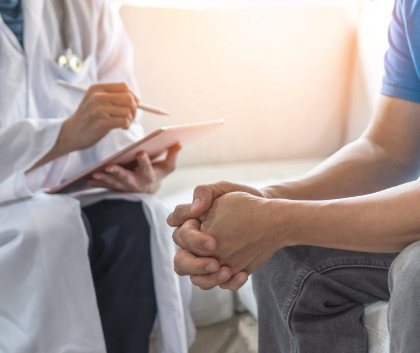Arzt stellt jungem Menschen eine Diagnose.