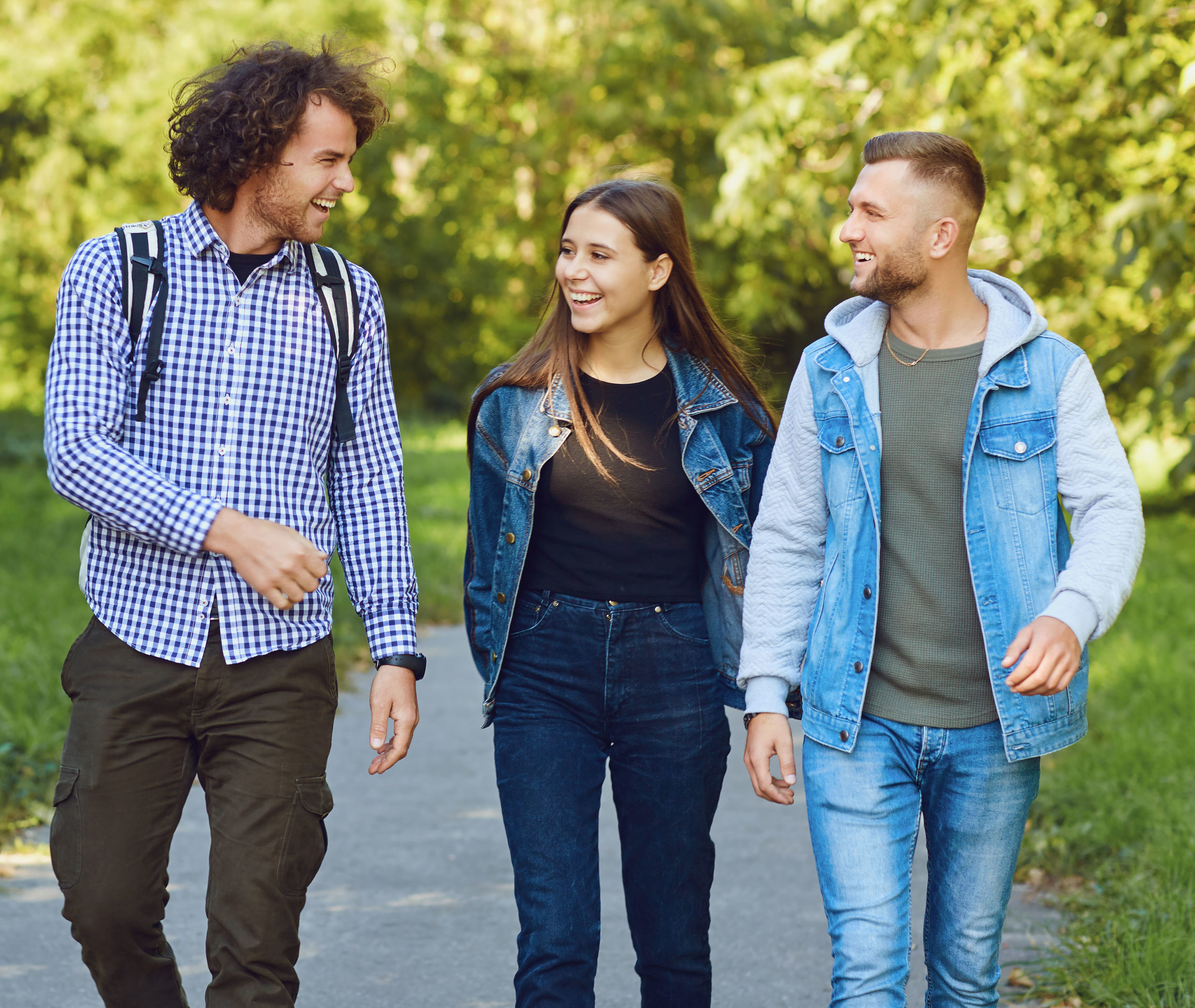 Vier junge Erwachsene beim Spaziergang in der Natur lachend