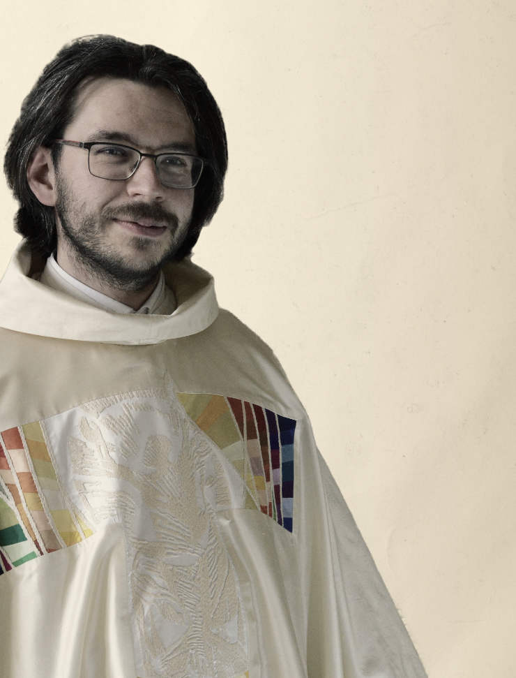 Junger Priester im weißen Priestergewand mit rechteckiger Brille