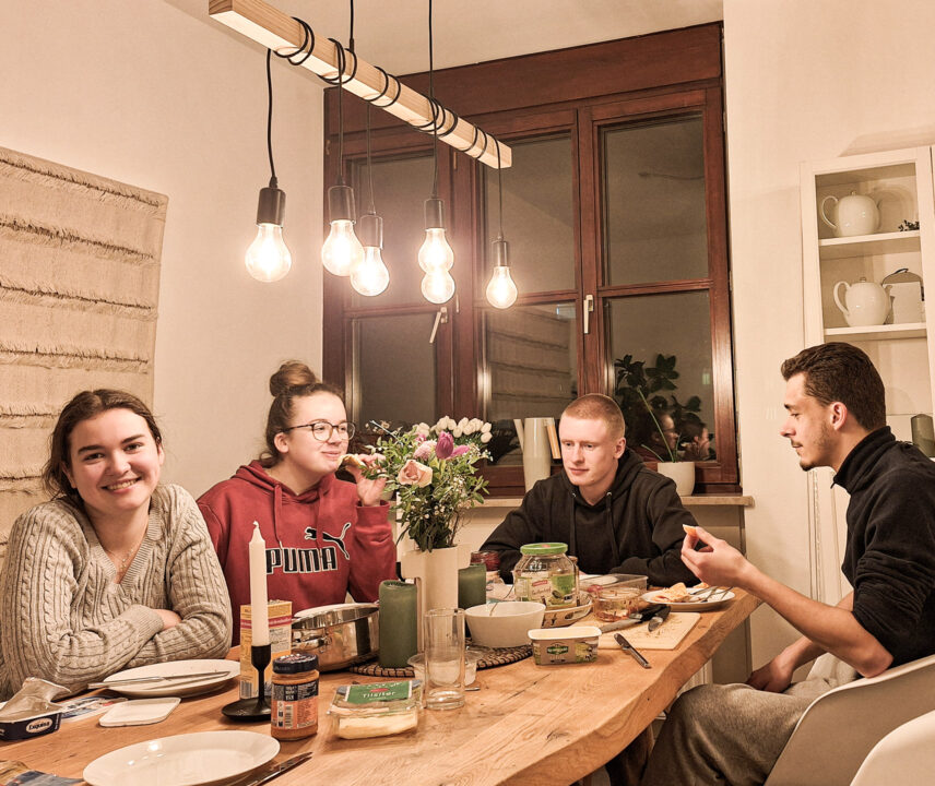 4 junge Leute beim Essen in einer WG.