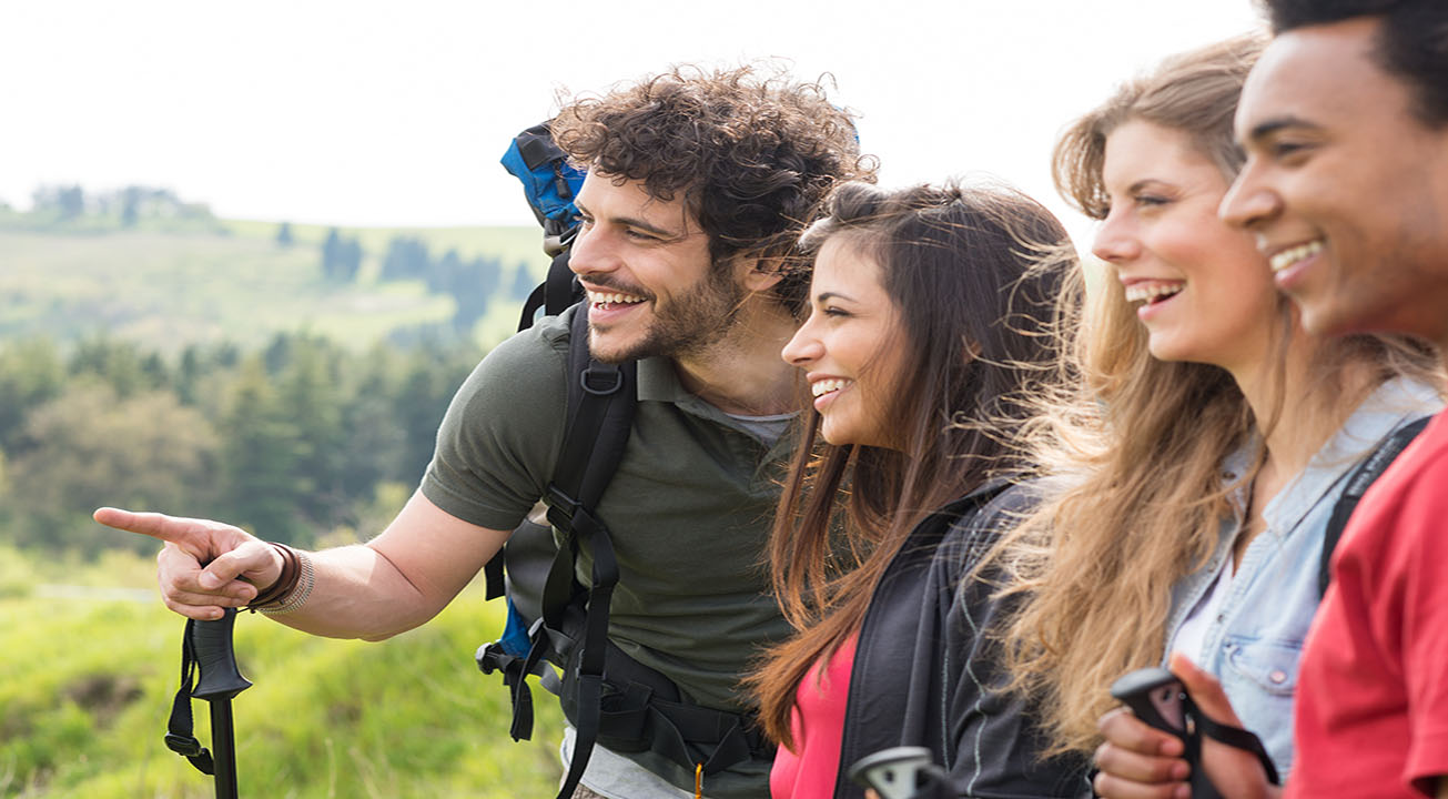 Vier junge Personen bewundern eine Landschaft